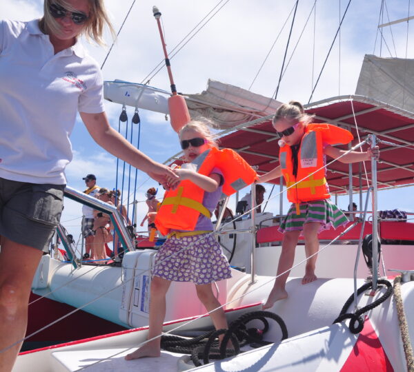 Ocean Diva Katamaran Crew hilft Kindern beim Anlegen der Schwimmweste