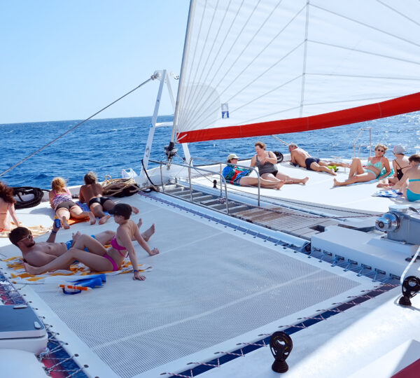 Ocean Diva Katamaran Gäste beim Sonnenbaden auf dem Netz-Deck während der Fahrt
